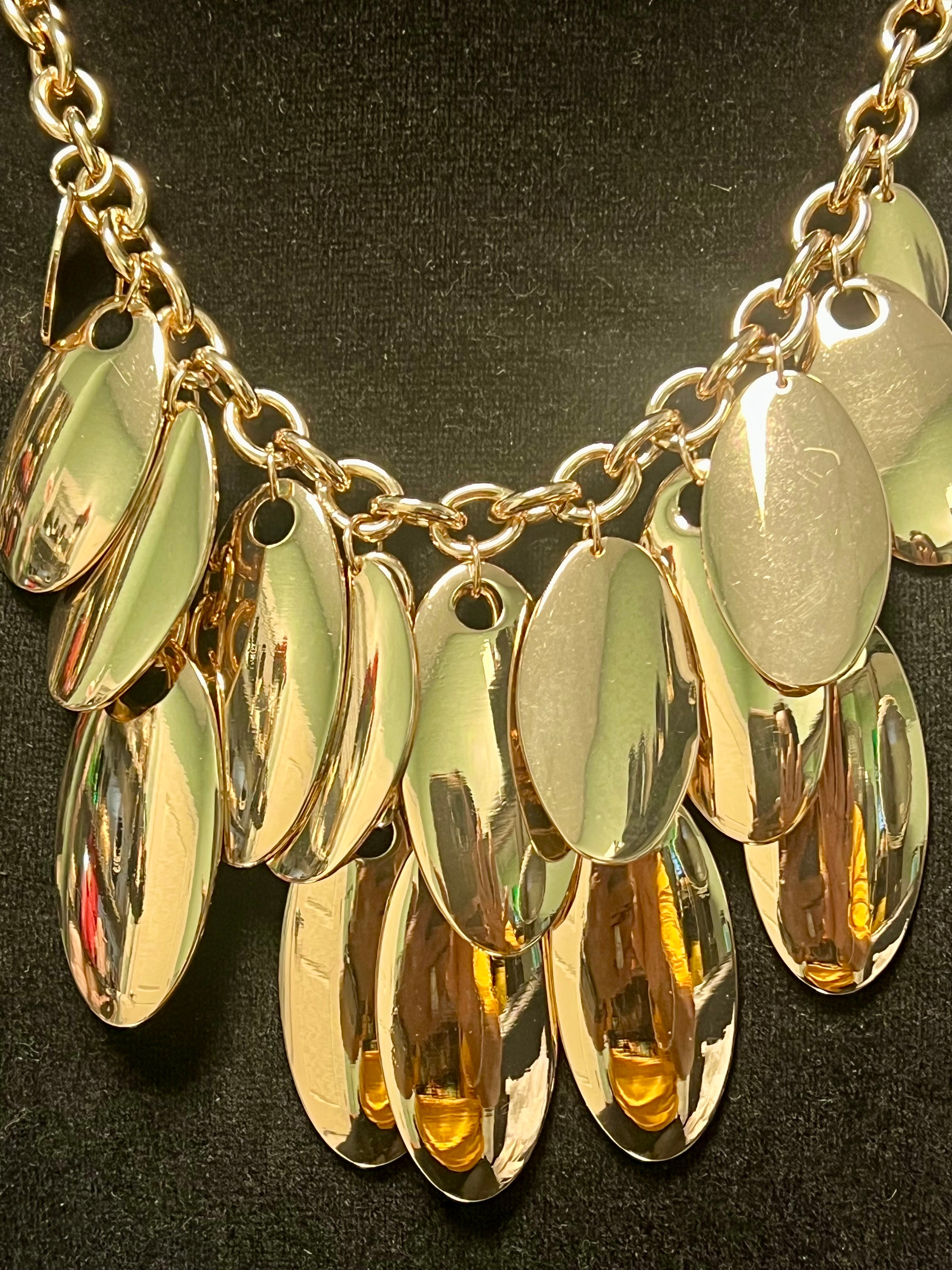Gold necklace with oval pendants on a dark background