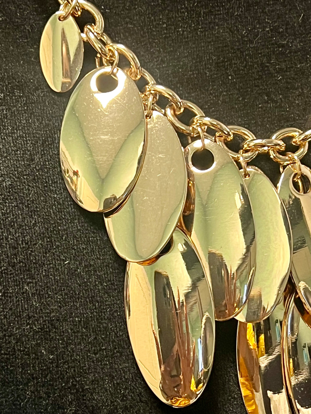 Gold chain with oval pendants on a black background