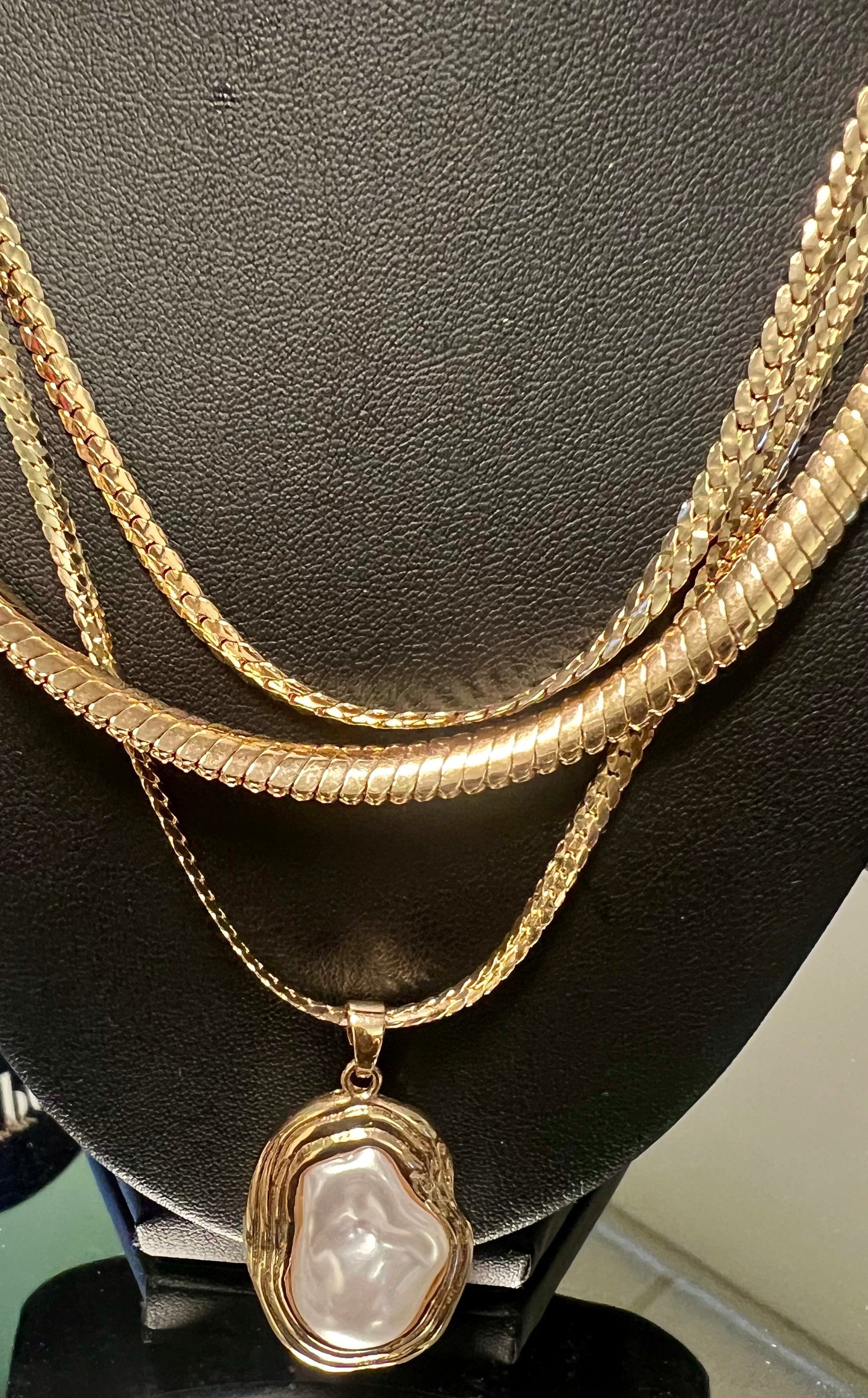 Gold necklace with a pendant on a black stand