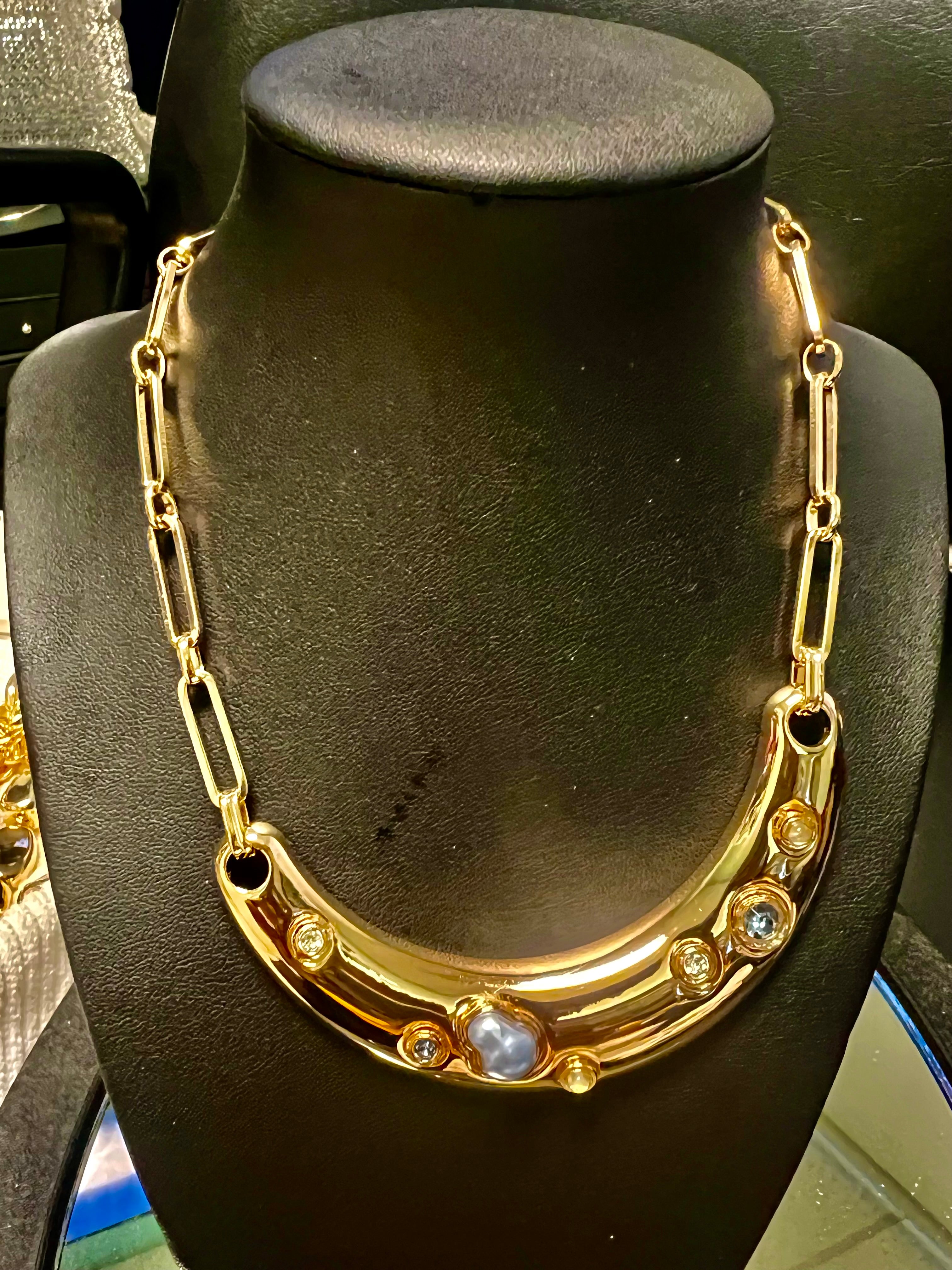 Gold necklace with gemstones on a black mannequin bust
