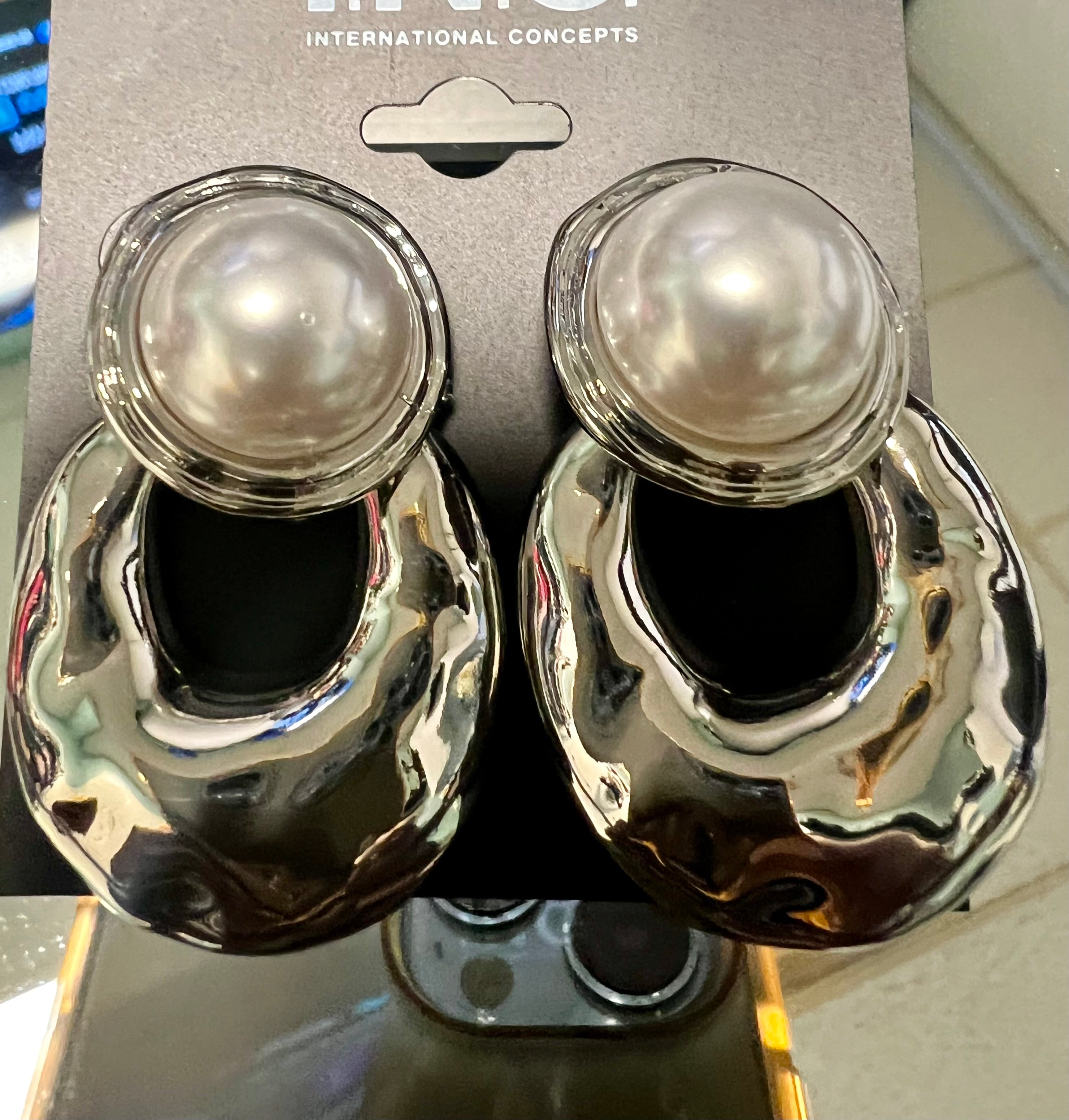 Pair of earrings with pearl-like centers on a branded card.