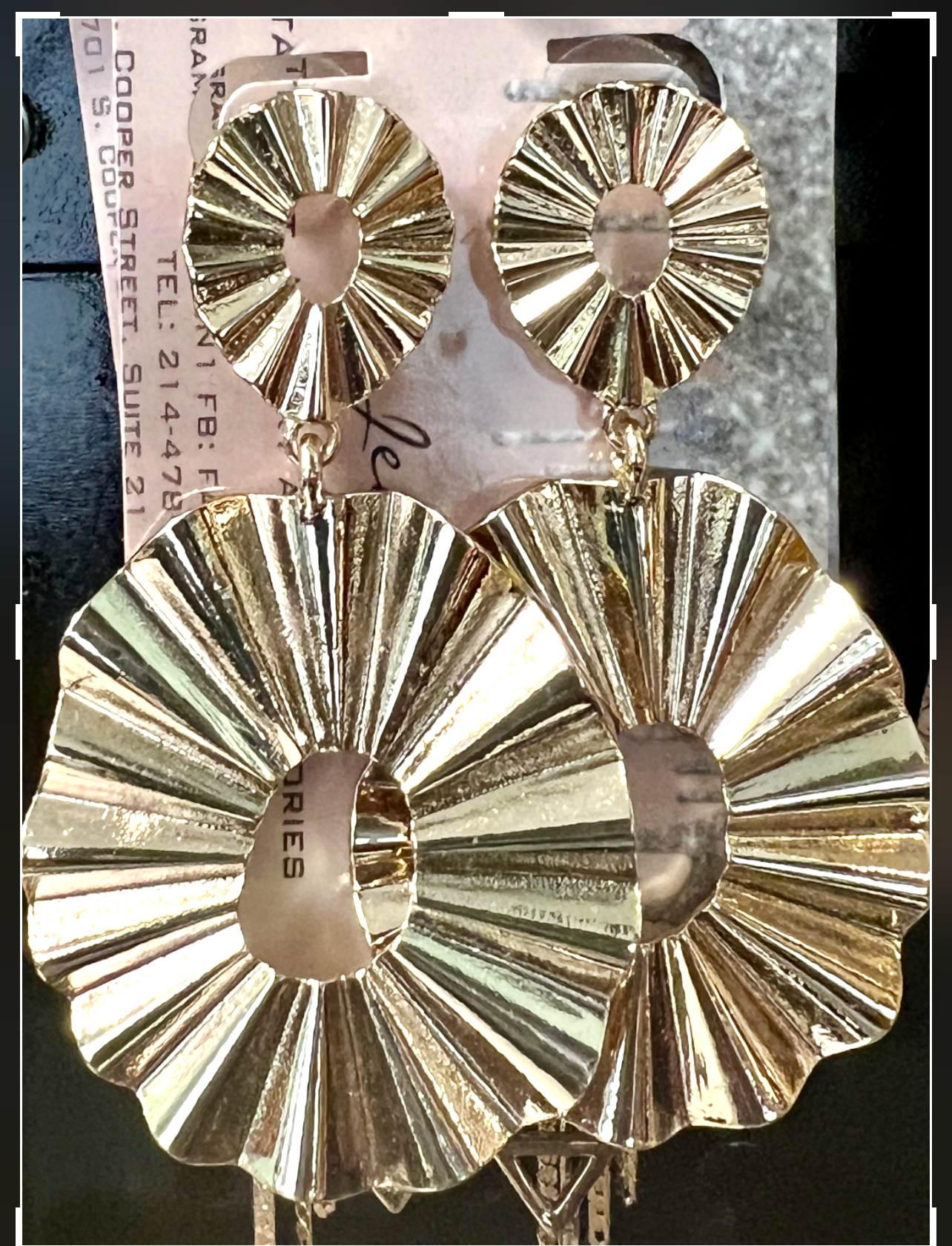 Gold earrings displayed on a phone screen with editing tools at the top.