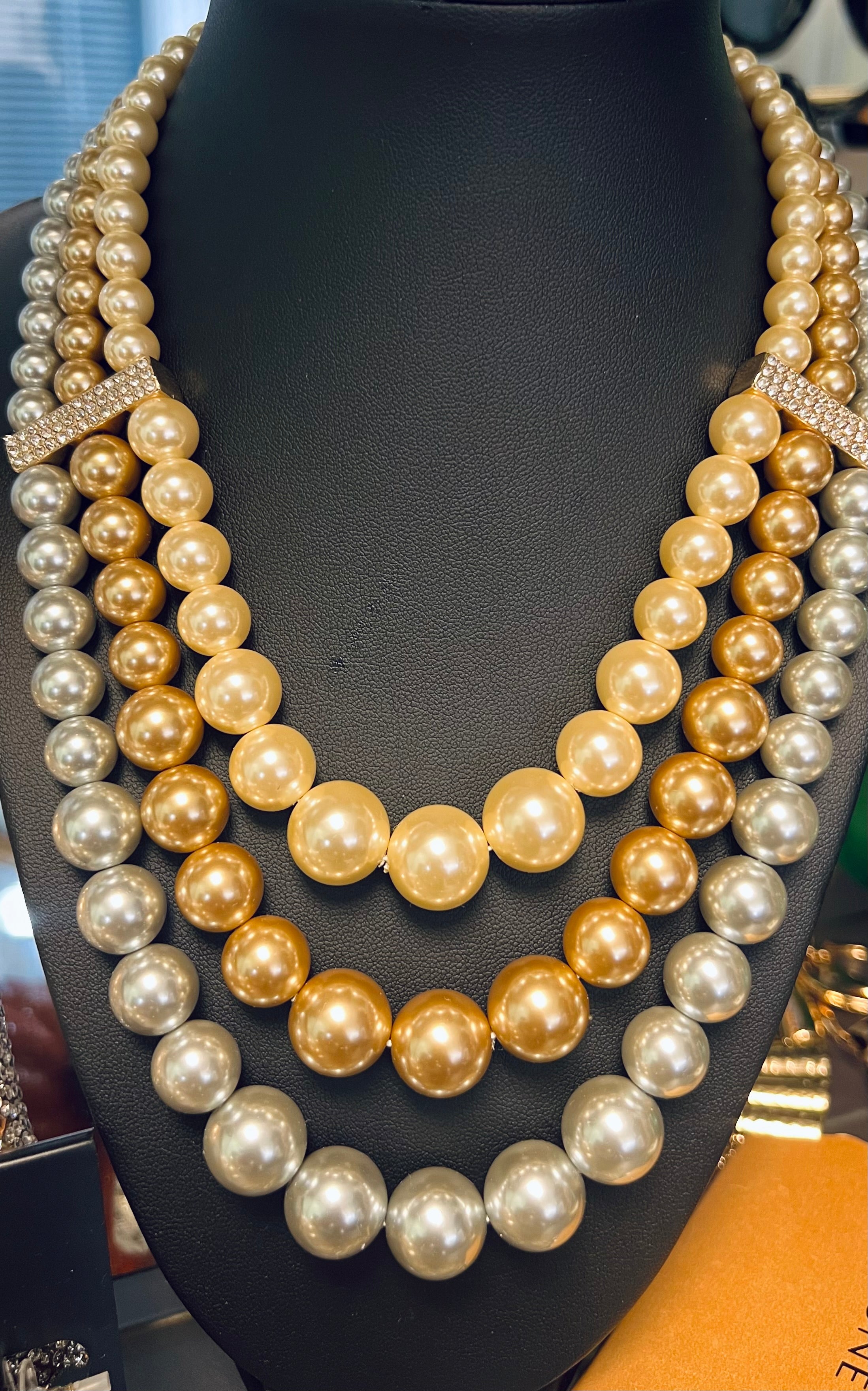 Multiple layers of pearl necklaces on a black mannequin