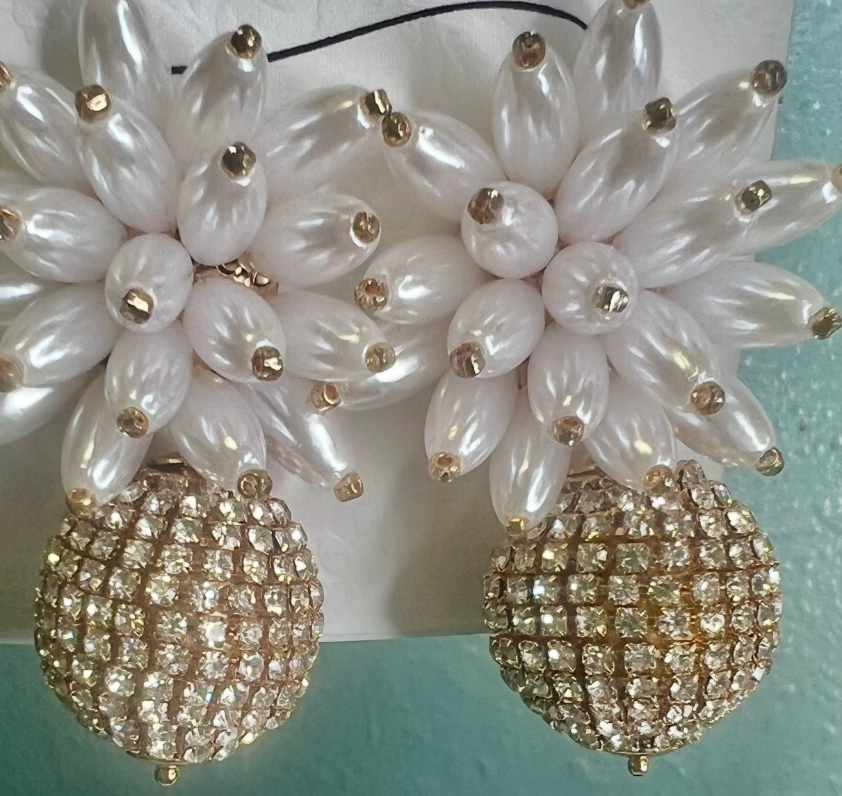 Pearl and crystal earrings on a light blue background