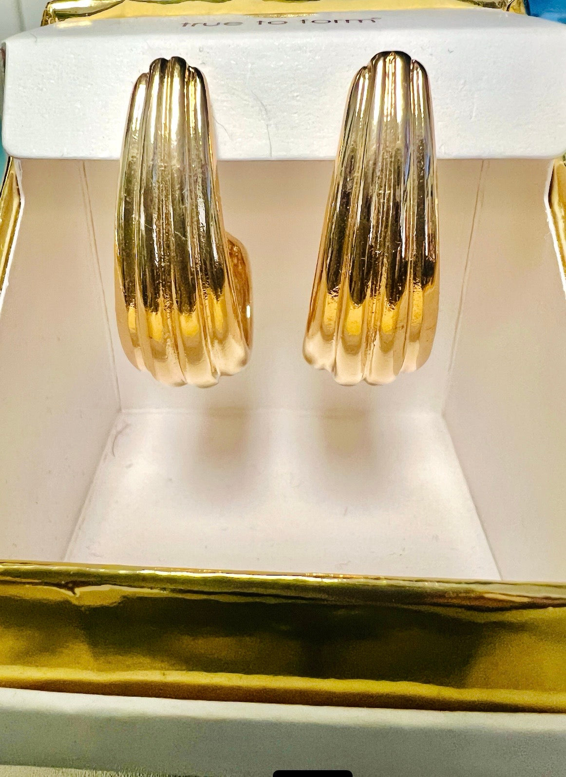 Gold hoop earrings displayed in a jewelry box